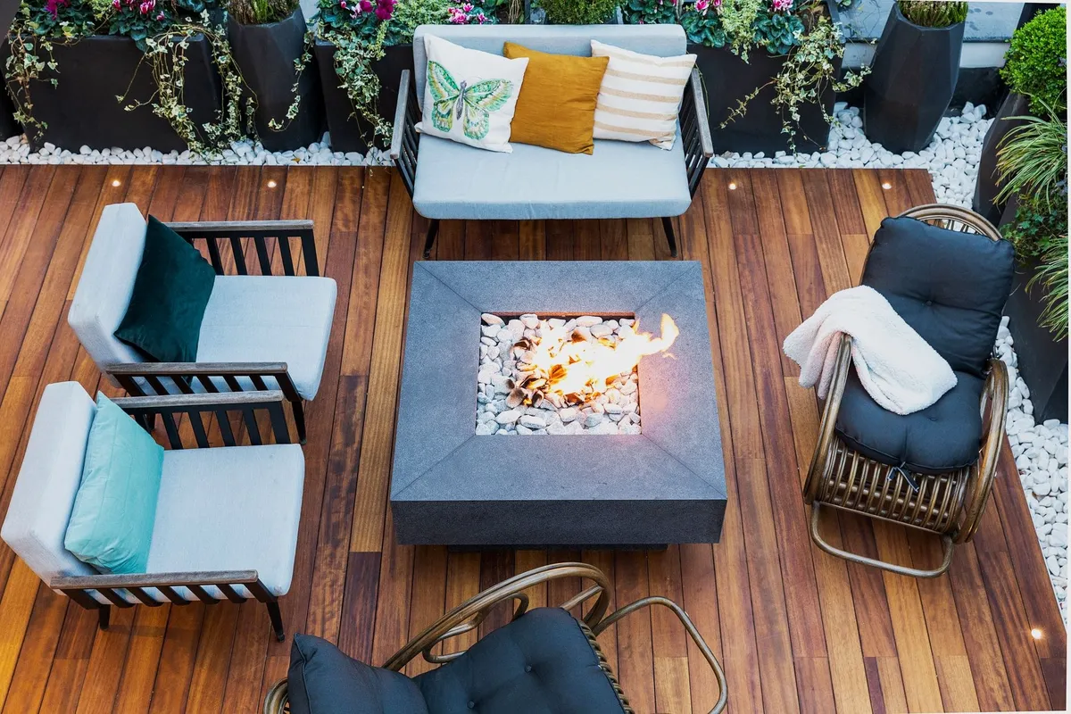 A modern patio with stylish furniture and a central firepit, illustrating ideal deck design elements.